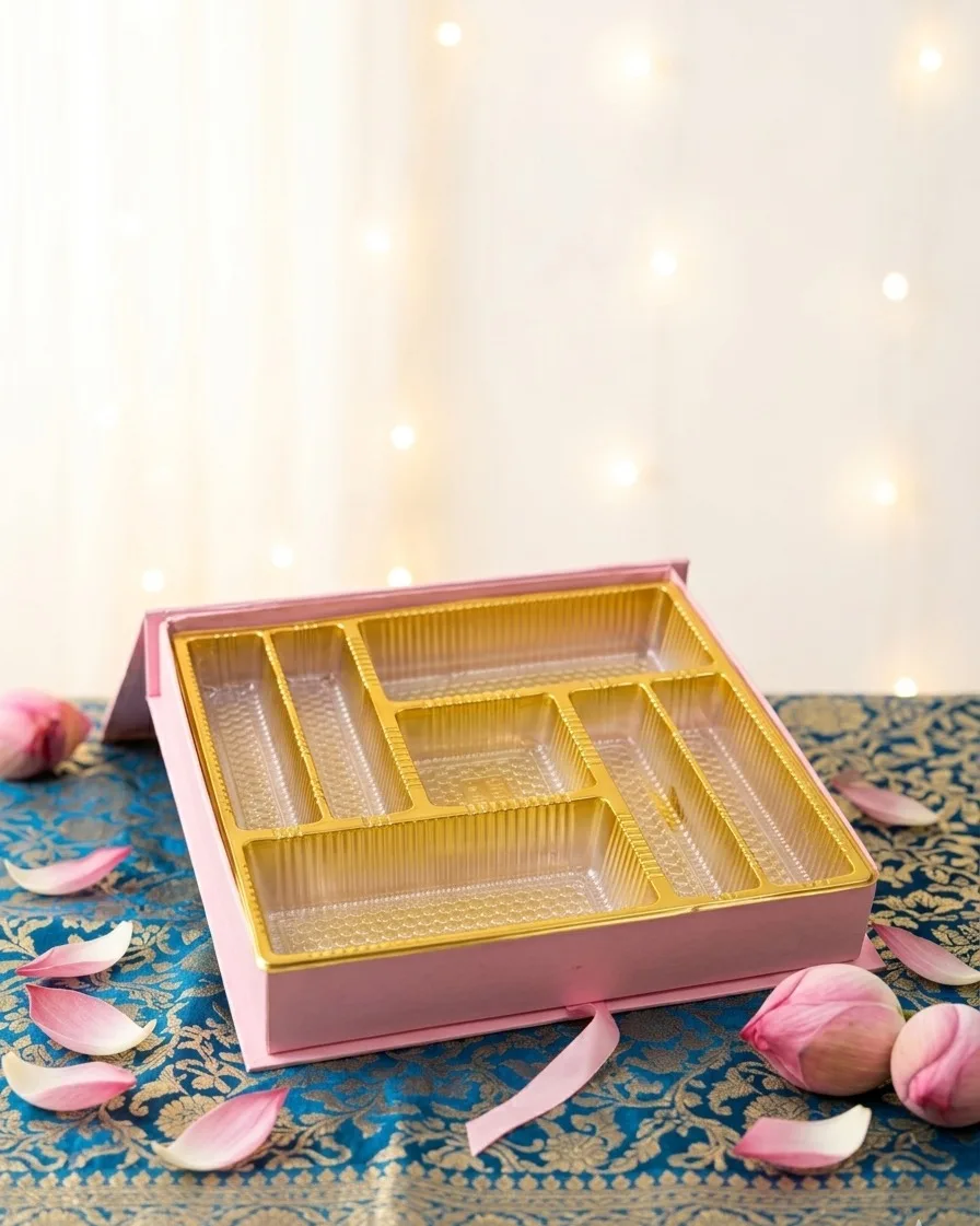 Pink box open showing a fitted gold tray